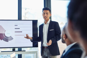A young business professional taking charge of a meeting in the boardroom.